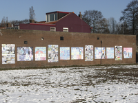 905757 Afbeelding van een serie uitvergrote kindertekeningen op een muur langs de hondenspeelplaats tussen de ...